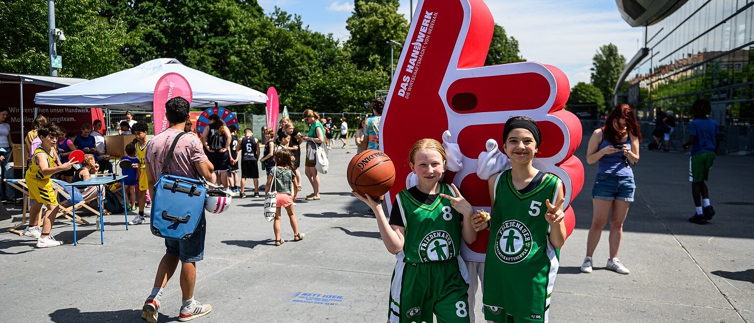 Zwei Schulkinder posieren beim Finale der ALBA Grundschulliga 2025 im Hof der Max-Schmeling-Halle